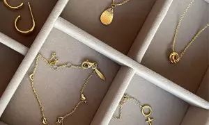 Ett urval av eleganta guld smycken herr: örhängen, halsband med hängsmycken och ett armband med hjärtan.
