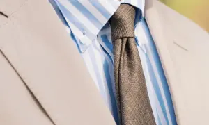 En brunmelerad slips till en ljusblårandig skjorta och en beige kostym. Klassisk stil för alla tillfällen.