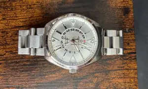 Eterna Kontiki-klocka med silverfärgad urtavla och metallänk, ligger på ett träbord.