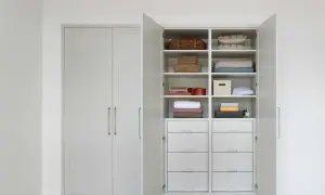 En öppen garderob med snygg förvaring av kuddar, filtar, korgar och lådor. Perfekt garderob inspo för ett organiserat hem.