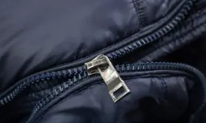 Detaljerad bild av en mörkblå jackas dragkedja. Kanske dags att laga dragkedja?