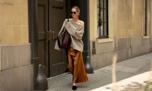 En kvinna går på gatan i en elegant outfit där brunt och svart ihop skapar en sofistikerad look.