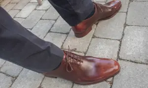 Ett par eleganta bruna läderskor med snörning, som visar hur lång tid det tar att gå in skor för en perfekt passform.