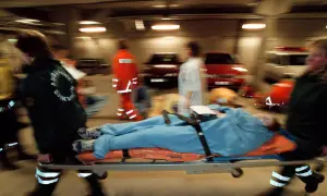 Ambulanspersonal bär en patient på bårbil. Tänk om dragkedja uppfinnare kunde se hur snabbt de arbetar.
