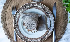 Vacker dukning med en tallrik och en servett vikt till kavaj. En fin detalj för en elegant middag.