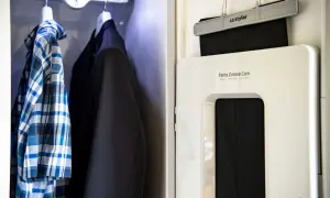 En rutig skjorta och en kavaj hänger redo. Bredvid syns en LG Styler som hjälper till att stryka skjorta med steamer och pressa byxveck.