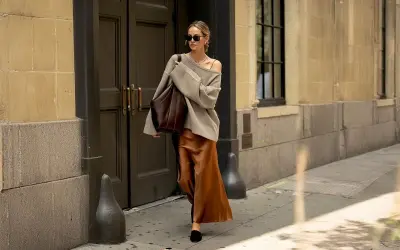 En kvinna går på gatan i en elegant outfit där brunt och svart ihop skapar en sofistikerad look.