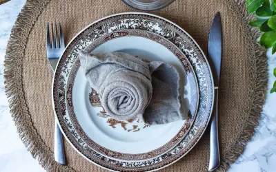 Vacker dukning med en tallrik och en servett vikt till kavaj. En fin detalj för en elegant middag.
