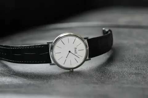 Elegant Piaget-klocka med vit urtavla och svart alligatorrem, perfekt som klocka till smoking.