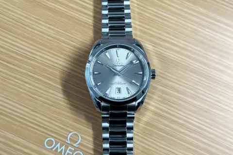 En elegant Omega Seamaster-klocka på en träbakgrund. Denna bild kan ge en ledtråd om hur fungerar en klocka, med dess detaljerade urtavla och armband.