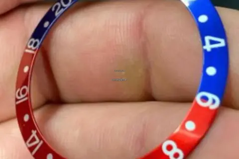 En närbild av en klockring med röd och blå färg, liknande en Pepsi-klocka. Siffror som 14, 16, 18, 20 och 4, 6, 8 syns.