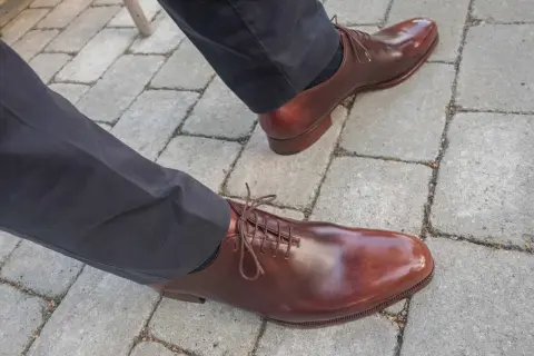 Ett par eleganta bruna läderskor med snörning, som visar hur lång tid det tar att gå in skor för en perfekt passform.