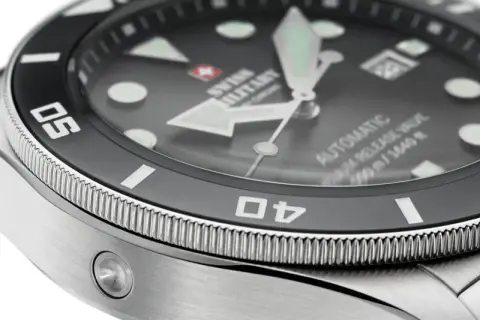 Detaljerad närbild av en dykarklocka med texten "SWISS MILITARY" och "AUTOMATIC 500m/1640ft". Klockans vattentäthet är imponerande.