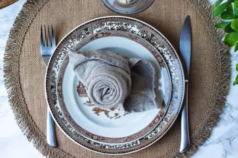 Vacker dukning med en tallrik och en servett vikt till kavaj. En fin detalj för en elegant middag.
