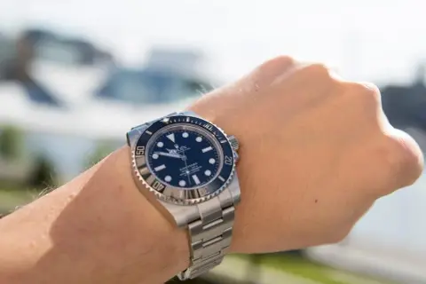 En handled med en Rolex Submariner. Klockan är redo för äventyr, kanske en tur med båten.