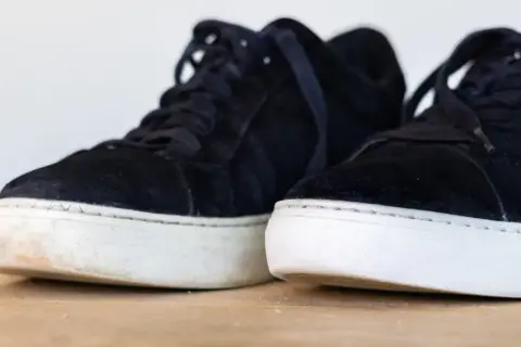 Två mörka mockaskor med vita sulor. Den ena skon är lite smutsig vid sulan, en påminnelse om att det är dags att impregnera uggs.