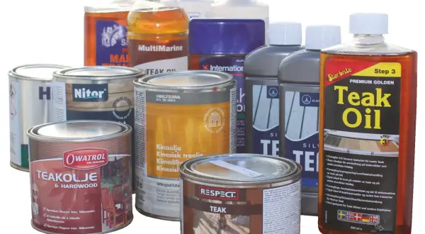 Flera burkar och flaskor med teakolja och träskyddsmedel. En burk har texten "impregneringsspray biltema" och en annan "Teak Oil".