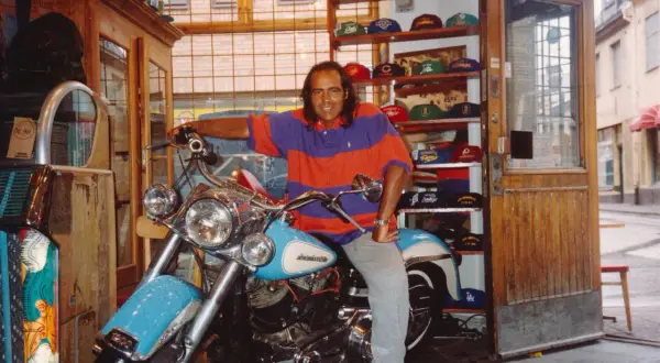 Man på motorcykel i en butik med kepsar, kanske en del av "Broadway & Sons" sortiment.