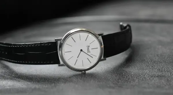 Elegant Piaget-klocka med vit urtavla och svart alligatorrem, perfekt som klocka till smoking.