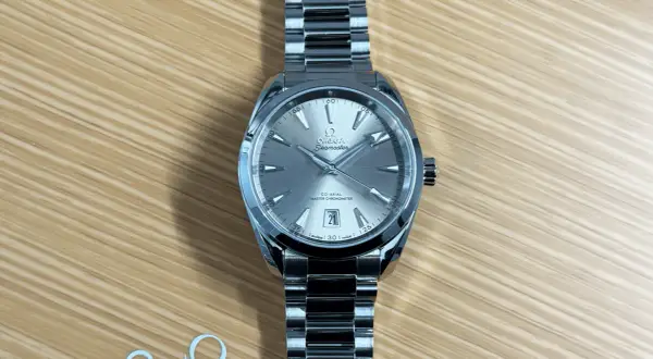 En elegant Omega Seamaster-klocka på en träbakgrund. Denna bild kan ge en ledtråd om hur fungerar en klocka, med dess detaljerade urtavla och armband.