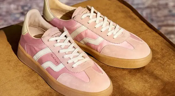 Ett par rosa sneakers från Gant med vita detaljer och snören, på en brun sammetsyta. Dessa skor är verkligen gott på foten för en stilfull vardag.