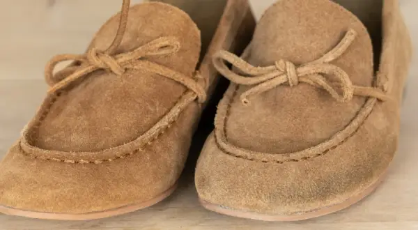 Två ljusbruna mockaskor med snörning och söm. Materialet i mocka ger en mjuk och lyxig känsla.