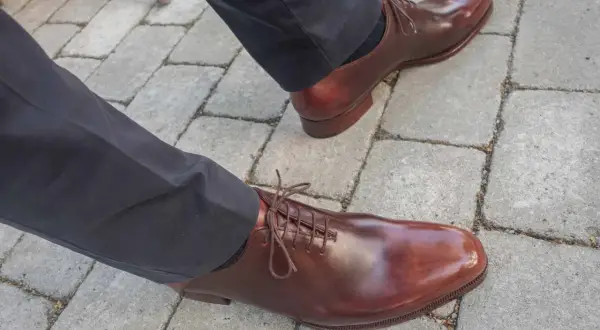 Ett par eleganta bruna läderskor med snörning, som visar hur lång tid det tar att gå in skor för en perfekt passform.