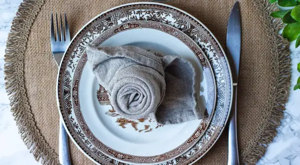 Vacker dukning med en tallrik och en servett vikt till kavaj. En fin detalj för en elegant middag.