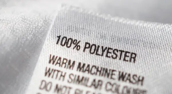 Tvättlapp visar 100% polyester, ett syntetiskt material. Skötselråd: varm maskintvätt med liknande färger.