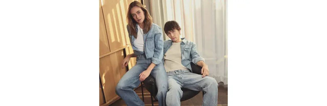 Ett par i helblått, en trendig double denim-look. Hon bär en jeansskjorta och jeans, han en jeansskjorta och jeans.