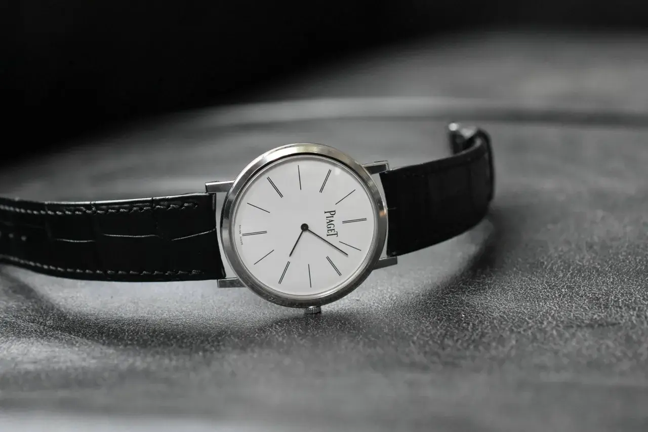 Elegant Piaget-klocka med vit urtavla och svart alligatorrem, perfekt som klocka till smoking.