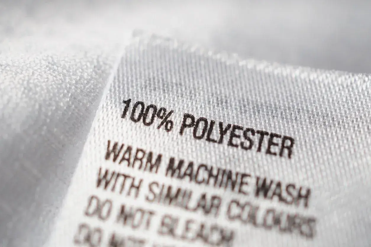 Tvättlapp visar 100% polyester, ett syntetiskt material. Skötselråd: varm maskintvätt med liknande färger.