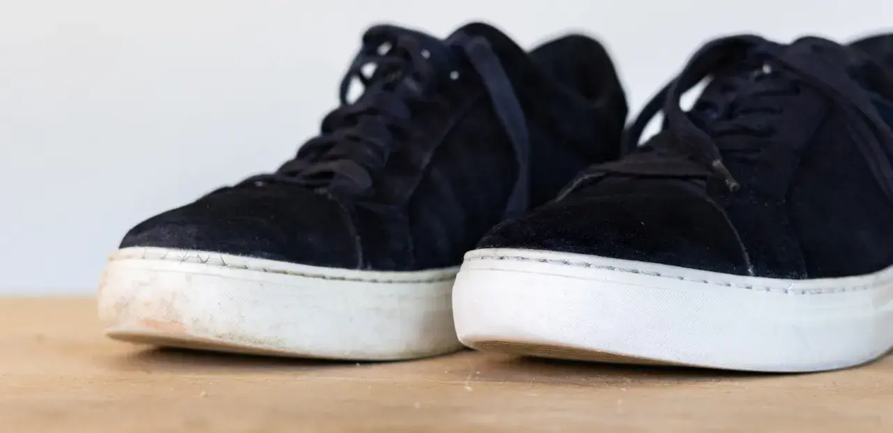 Två mörka mockaskor med vita sulor. Den ena skon är lite smutsig vid sulan, en påminnelse om att det är dags att impregnera uggs.