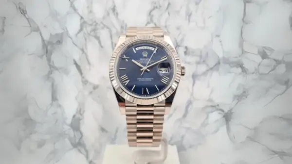 En lyxig Rolex Day-Date med blå urtavla och gulddetaljer, ett perfekt exempel på schweizisk tillverkning.