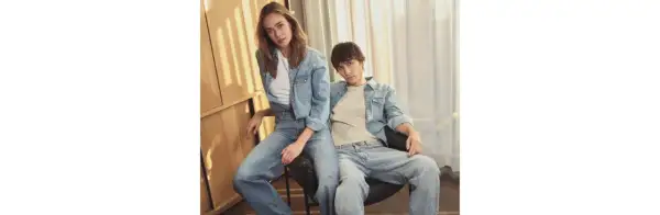 Ett par i helblått, en trendig double denim-look. Hon bär en jeansskjorta och jeans, han en jeansskjorta och jeans.