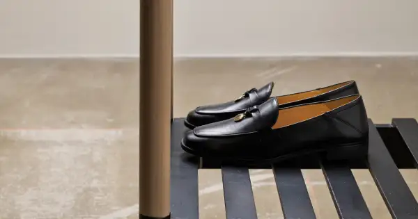 Eleganta svarta loafers till kostym, med gulddetaljer. Perfekta för en stilfull look.