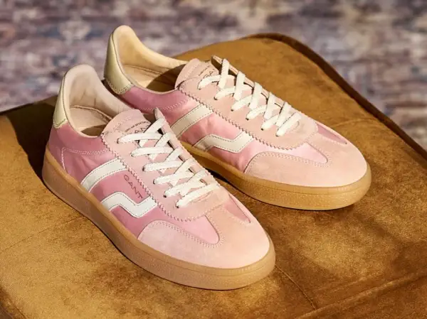 Ett par rosa sneakers från Gant med vita detaljer och snören, på en brun sammetsyta. Dessa skor är verkligen gott på foten för en stilfull vardag.