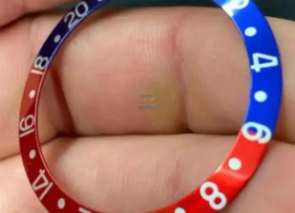 En närbild av en klockring med röd och blå färg, liknande en Pepsi-klocka. Siffror som 14, 16, 18, 20 och 4, 6, 8 syns.