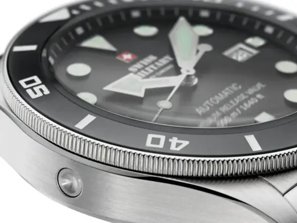 Detaljerad närbild av en dykarklocka med texten "SWISS MILITARY" och "AUTOMATIC 500m/1640ft". Klockans vattentäthet är imponerande.