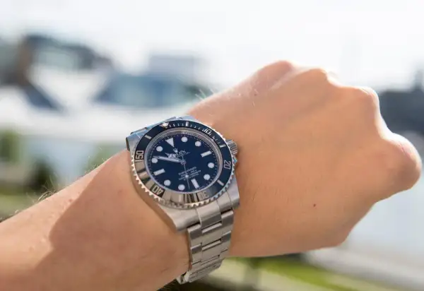 En handled med en Rolex Submariner. Klockan är redo för äventyr, kanske en tur med båten.