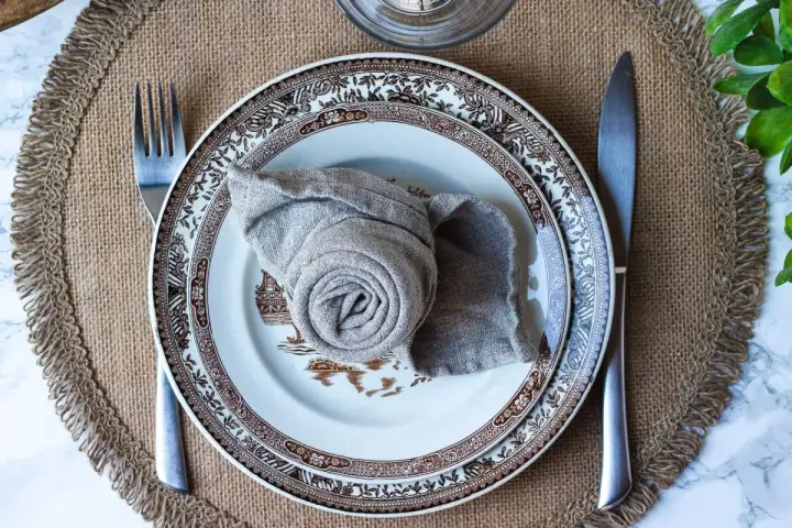 Vacker dukning med en tallrik och en servett vikt till kavaj. En fin detalj för en elegant middag.
